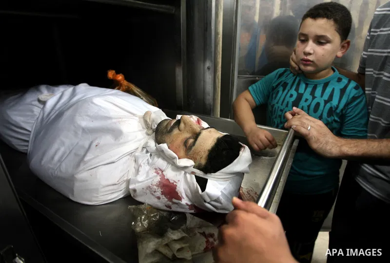 The son of Palestinian Islamic Jihad militant Ismael Al-Asmar mourn over his body at Rafah hospital after an Israeli air strike hit his car in Rafah in the southern Gaza Strip on 24 August 2011. Al-Asmar, one of the mili...