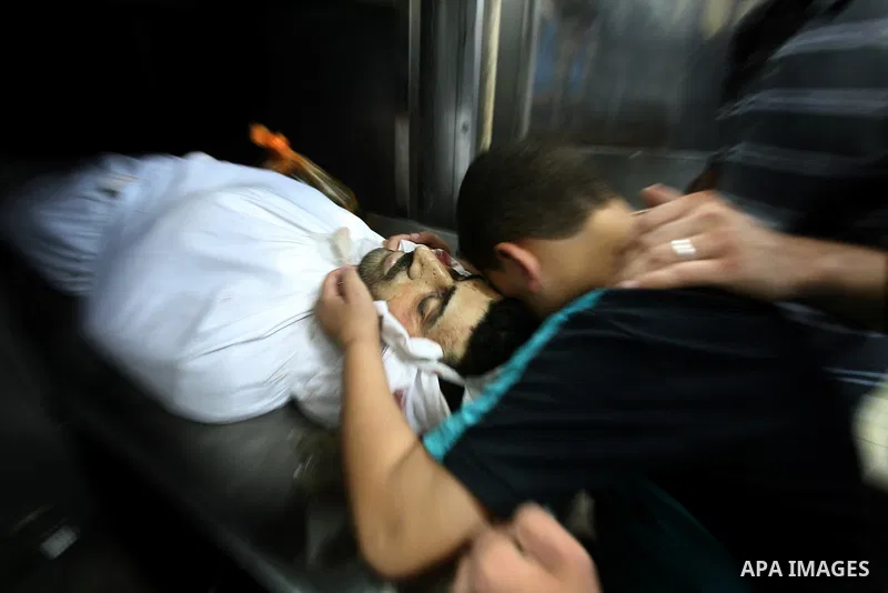 The son of Palestinian Islamic Jihad militant Ismael Al-Asmar mourn over his body at Rafah hospital after an Israeli air strike hit his car in Rafah in the southern Gaza Strip on 24 August 2011. Al-Asmar, one of the mili...