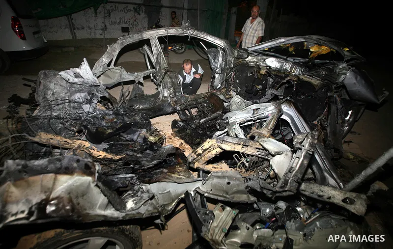 Palestinians check the damage to a car after an Israeli air strike in Rafah in the southern Gaza Strip, on August 24, 2011. Ismael Al-Asmar, one of the militant leaders of the group Islamic Jihad , was killed in the air...