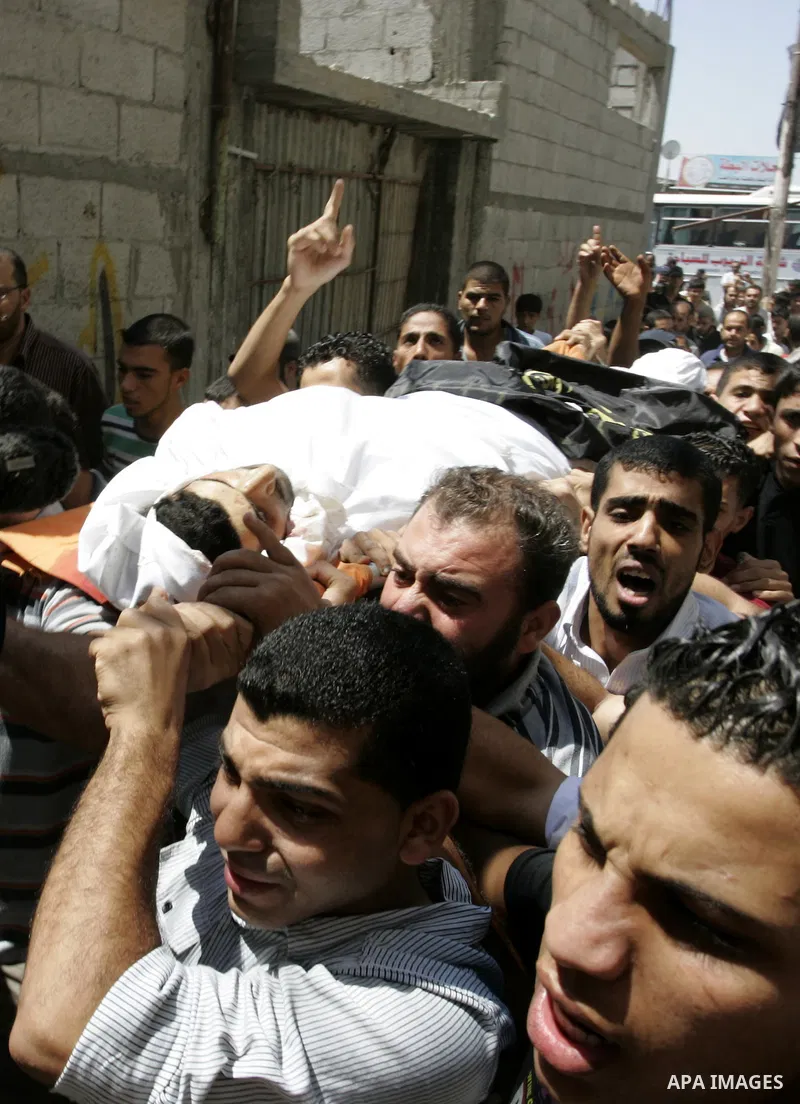Palestinian mourners carry the body of Islamic Jihad militant Ismael Al-Asmar during his funeral after an Israeli air strike hit his car in Rafah in the southern Gaza Strip on 24 August 2011. Al-Asmar, one of the militan...