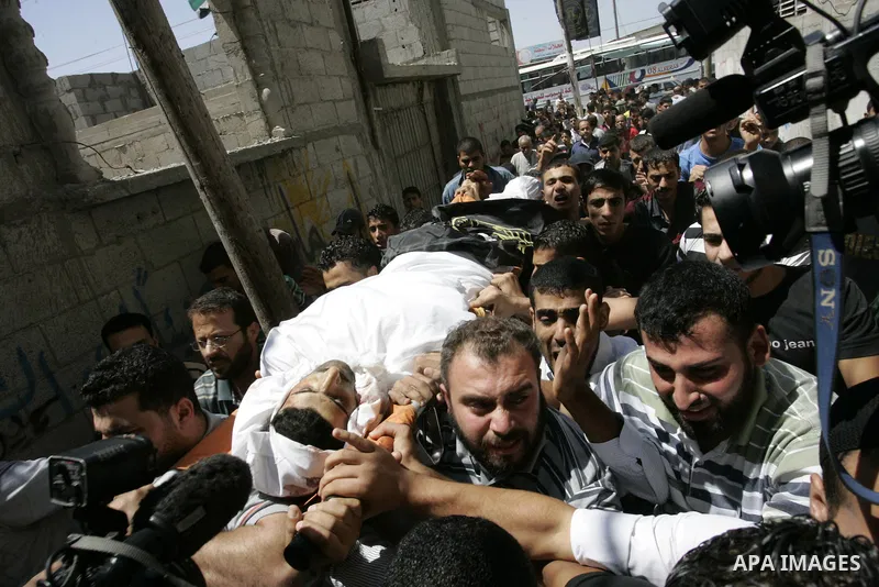 Palestinian mourners carry the body of Islamic Jihad militant Ismael Al-Asmar during his funeral after an Israeli air strike hit his car in Rafah in the southern Gaza Strip on 24 August 2011. Al-Asmar, one of the militan...