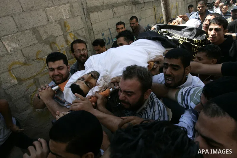 Palestinian mourners carry the body of Islamic Jihad militant Ismael Al-Asmar during his funeral after an Israeli air strike hit his car in Rafah in the southern Gaza Strip on 24 August 2011. Al-Asmar, one of the militan...