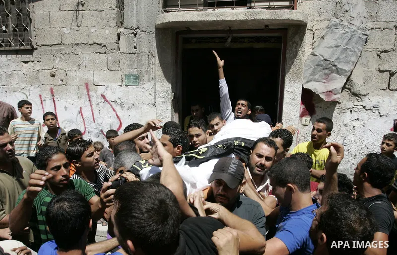 Palestinian mourners carry the body of Islamic Jihad militant Ismael Al-Asmar during his funeral after an Israeli air strike hit his car in Rafah in the southern Gaza Strip on 24 August 2011. Al-Asmar, one of the militan...