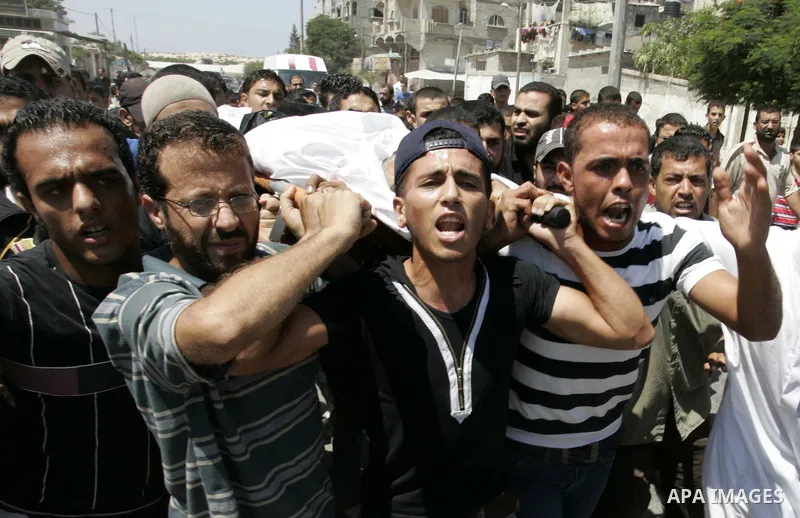 Palestinian mourners carry the body of Islamic Jihad militant Ismael Al-Asmar during his funeral after an Israeli air strike hit his car in Rafah in the southern Gaza Strip on 24 August 2011. Al-Asmar, one of the militan...