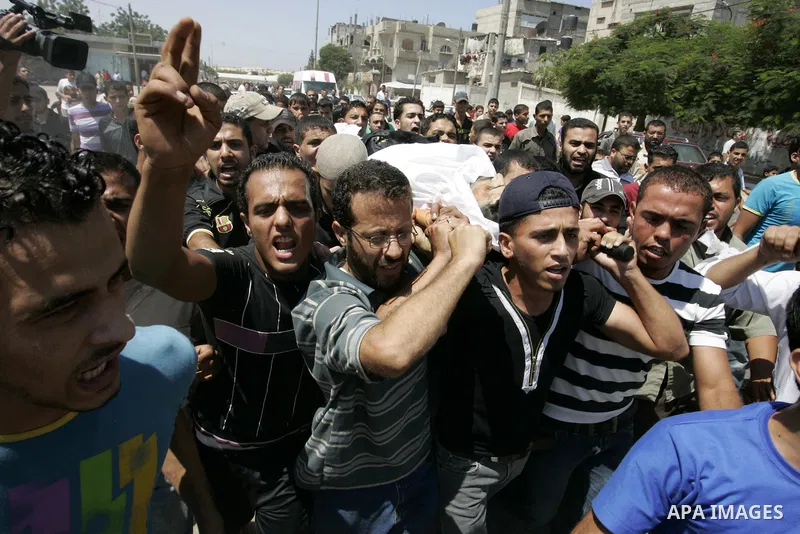 Palestinian mourners carry the body of Islamic Jihad militant Ismael Al-Asmar during his funeral after an Israeli air strike hit his car in Rafah in the southern Gaza Strip on 24 August 2011. Al-Asmar, one of the militan...