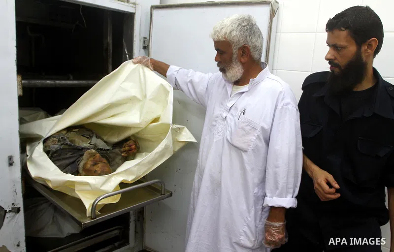 Palestinians gather around the body of Ismail Amum ,65, at Al-Aqsa hospital morgue in the central Gaza Strip on August 24,2011. Israeli air strikes killed a local commander of the Islamic Jihad militant group in the Gaza...