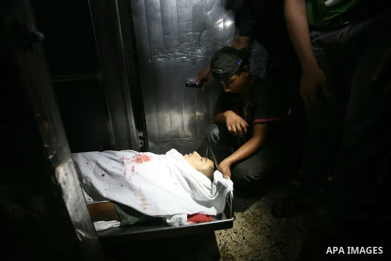 Palestinian men react at a hospital upon the arrival of the body of a militant killed in an Israeli air strike in Gaza City on 25 August 2011. Israeli air strikes killed two Gaza militants, one a local commander of the I...