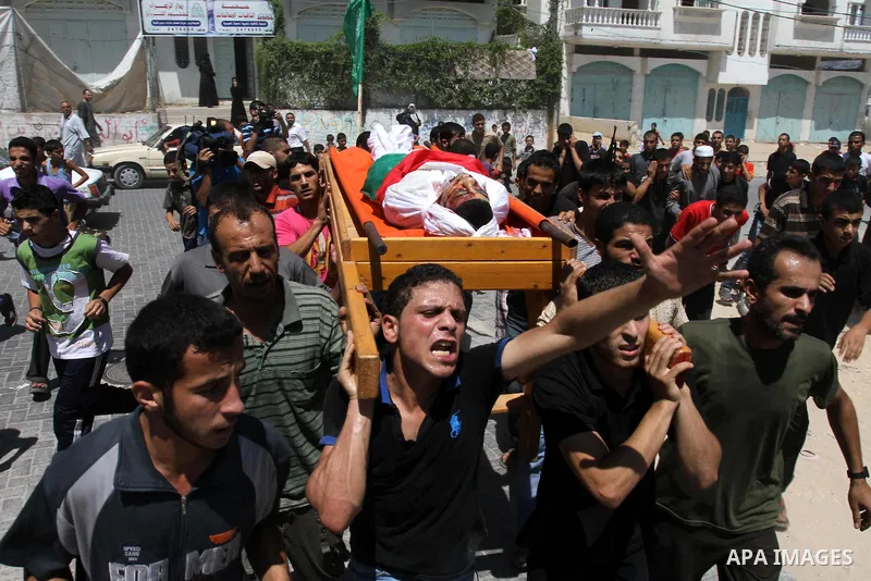 Palestinian mourners carry the body of Salama Al-Masri eighteen years-old during his funeral in the northern in Gaza Strip town of Beit-Lahia on August 25, 2011. Israeli warplanes hit a sports club run by Islamic Jihad i...