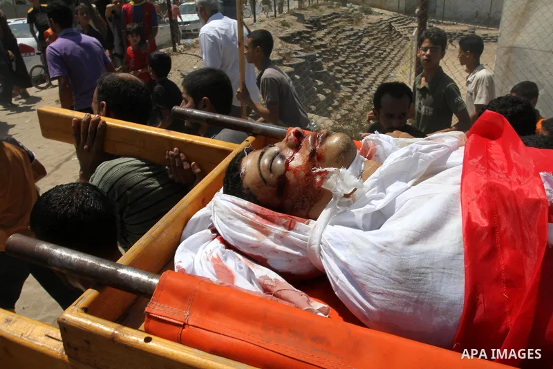 Palestinian mourners carry the body of Salama Al-Masri eighteen years-old during his funeral in the northern in Gaza Strip town of Beit-Lahia on August 25, 2011. Israeli warplanes hit a sports club run by Islamic Jihad i...