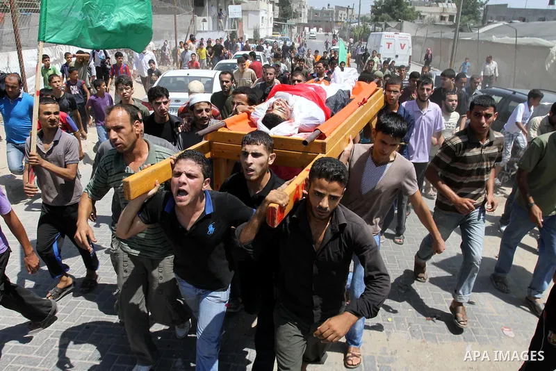 Palestinian mourners carry the body of Salama Al-Masri eighteen years-old during his funeral in the northern in Gaza Strip town of Beit-Lahia on August 25, 2011. Israeli warplanes hit a sports club run by Islamic Jihad i...