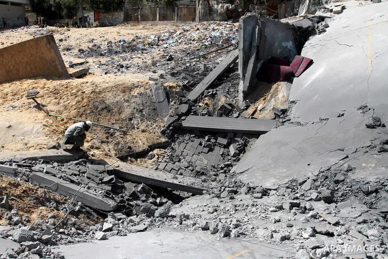 Palestinians inspect the grounds of a sporting club and the homes of some citizens that was destroyed by an overnight Israeli air raid in Beit Lahia, on August 25, 2011. A series of Israeli air strikes on Gaza over the p...
