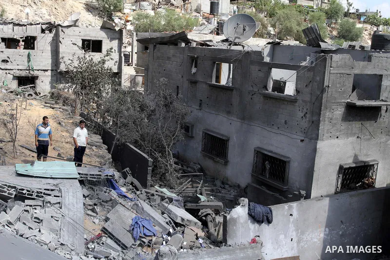 Palestinians inspect the grounds of a sporting club and the homes of some citizens that was destroyed by an overnight Israeli air raid in Beit Lahia, on August 25, 2011. A series of Israeli air strikes on Gaza over the p...