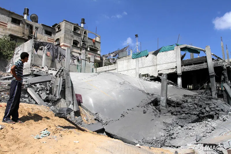 Palestinians inspect the grounds of a sporting club and the homes of some citizens that was destroyed by an overnight Israeli air raid in Beit Lahia, on August 25, 2011. A series of Israeli air strikes on Gaza over the p...