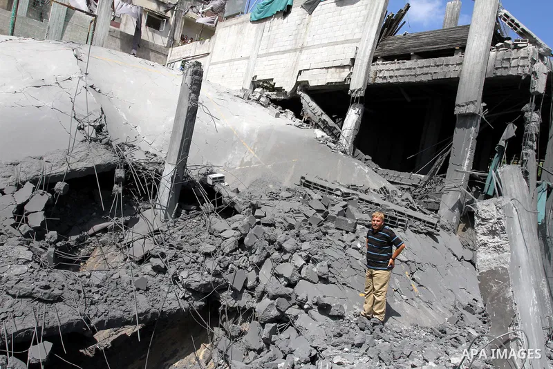 Palestinians inspect the grounds of a sporting club and the homes of some citizens that was destroyed by an overnight Israeli air raid in Beit Lahia, on August 25, 2011. A series of Israeli air strikes on Gaza over the p...