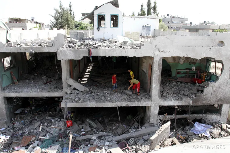 Palestinians inspect the grounds of a sporting club and the homes of some citizens that was destroyed by an overnight Israeli air raid in Beit Lahia, on August 25, 2011. A series of Israeli air strikes on Gaza over the p...