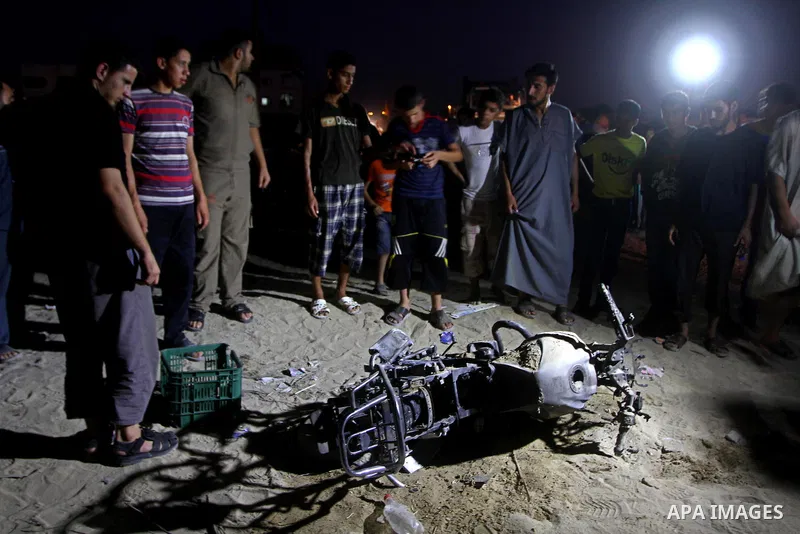 Palestinians gather around a destroyed motorcycle following an Israeli air strike killing two Islamic Jihad militants, at the main road in Jabaliya, northern Gaza Strip, Thursday, Aug. 25, 2011. Palestinian official said...