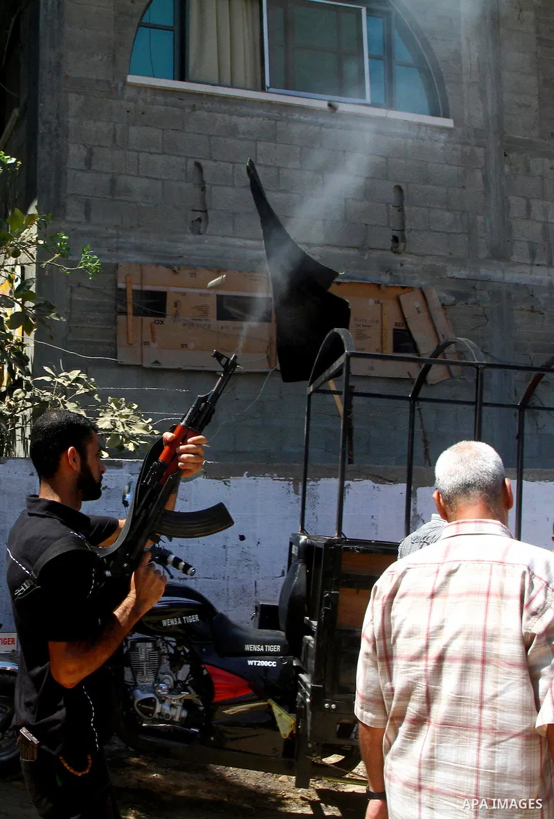 A Palestinian militant of Islamic Jihad shots fire during the funeral of Alaa Hamdan and Saleem al-Arabid in Gaza City on August, 26,2011 after Palestinian groups in the Gaza Strip agreed on a new ceasefire after days of...