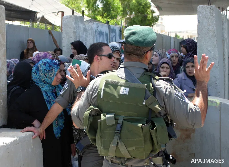 Palestinian women wait to pass the checkpoint on their way to pray at the Al Aqsa Mosque, on the last Friday of the Muslim holy month of Ramadan, in the West Bank town of Bethlehem, early Friday, Aug. 26, 2011. Muslims a...