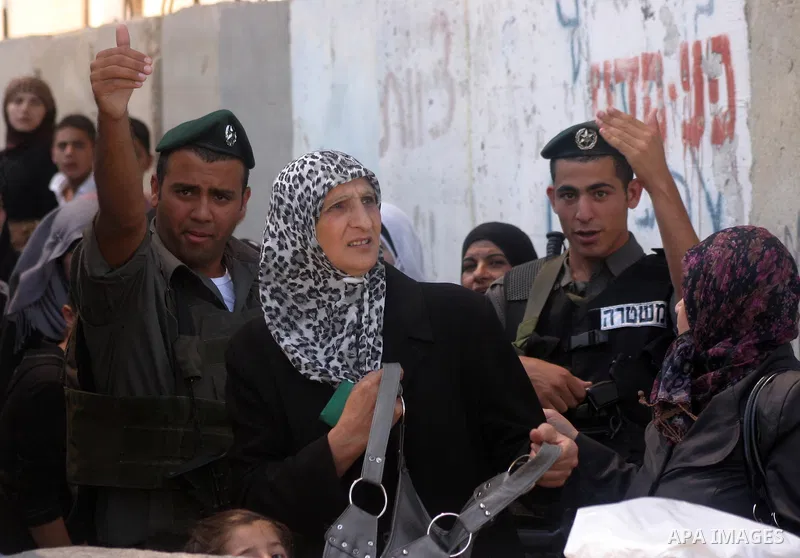 Palestinian women wait to pass the checkpoint on their way to pray at the Al Aqsa Mosque, on the last Friday of the Muslim holy month of Ramadan, in the West Bank town of Bethlehem, early Friday, Aug. 26, 2011. Muslims a...