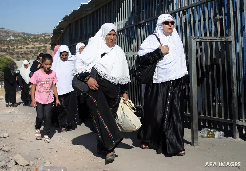 Palestinian women wait to pass the checkpoint on their way to pray at the Al Aqsa Mosque, on the last Friday of the Muslim holy month of Ramadan, in the West Bank town of Bethlehem, early Friday, Aug. 26, 2011. Muslims a...