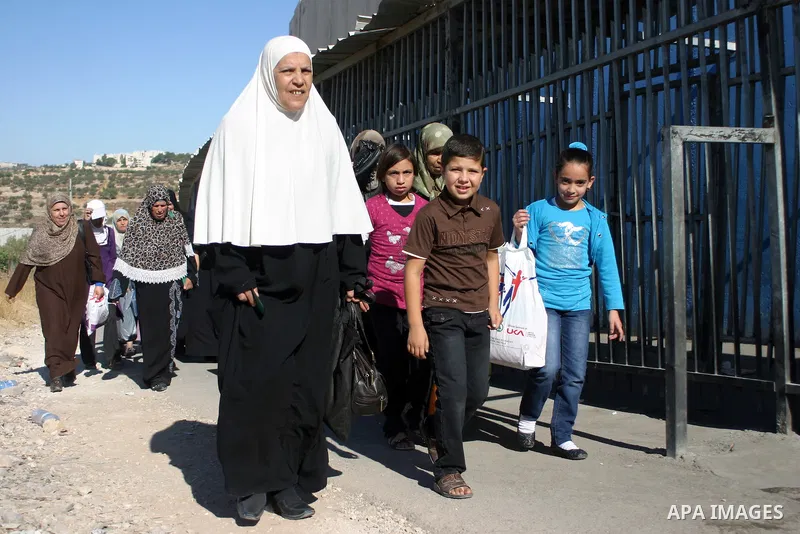 Palestinian women wait to pass the checkpoint on their way to pray at the Al Aqsa Mosque, on the last Friday of the Muslim holy month of Ramadan, in the West Bank town of Bethlehem, early Friday, Aug. 26, 2011. Muslims a...