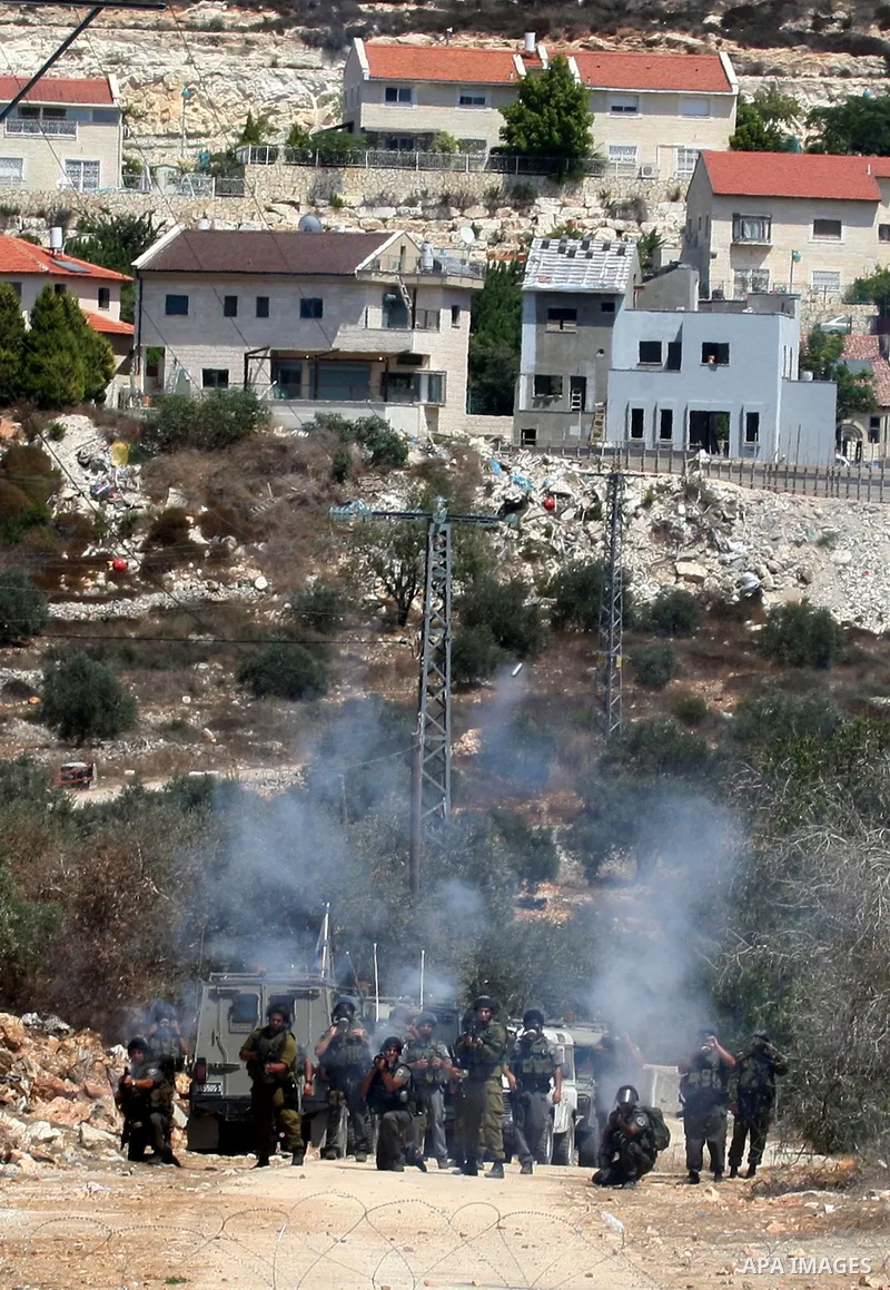 Israeli soldiers fire tear gas canisters toward Palestinian demonstrators during the weekly protest against the settlement of Qadomim, near the village of Kofr Qadom, west of Nablus City, in the Israeli-occupied West Ban...