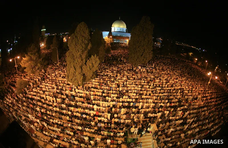 Palestinian muslim worshippers pray outside the Dome of the Rock in the Al-Aqsa Mosque compound in Jerusalem's Old City during the Islamic anniversary Lailat al-Qader, also known as the Night of Power, on August 27, 2011...