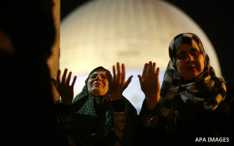 A Palestinian Muslim woman prays outside the Dome of the Rock in the Al-Aqsa Mosque compound in Jerusalem's Old City during the Islamic anniversary Lailat al-Qader, also known as the Night of Power, on August 27, 2011. P...