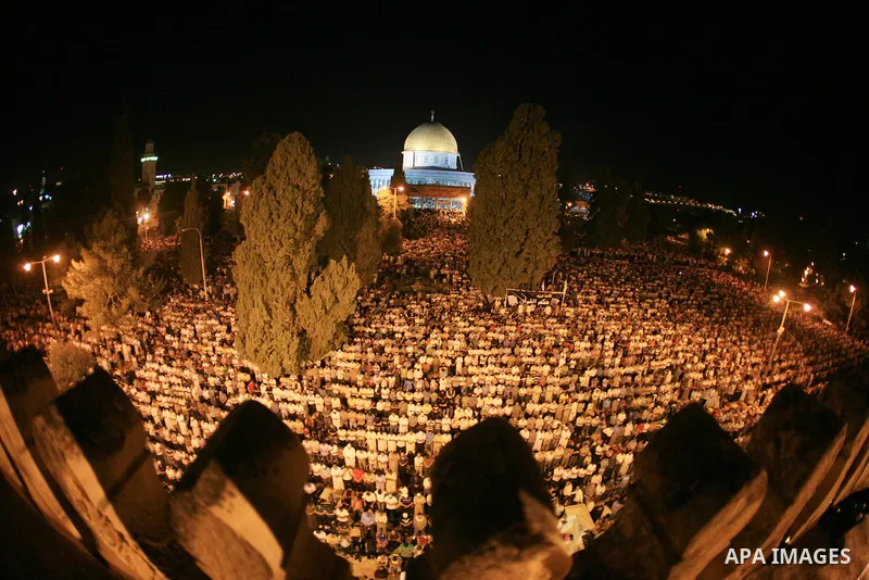 Palestinian muslim worshippers pray outside the Dome of the Rock in the Al-Aqsa Mosque compound in Jerusalem's Old City during the Islamic anniversary Lailat al-Qader, also known as the Night of Power, on August 27, 2011...
