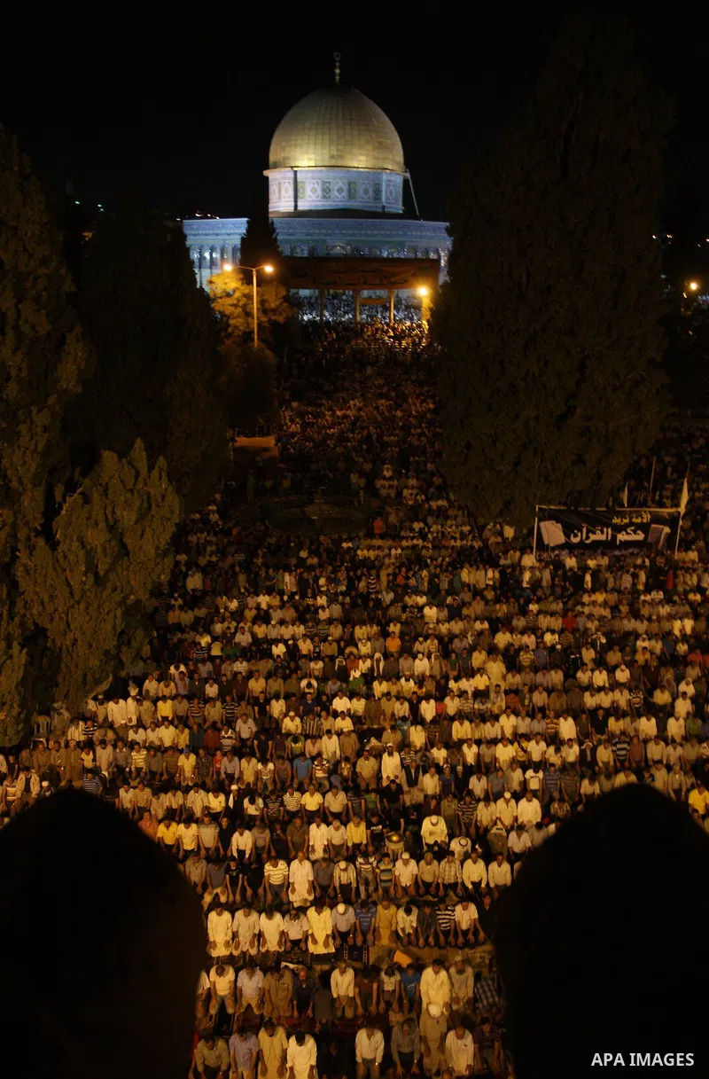 Palestinian muslim worshippers pray outside the Dome of the Rock in the Al-Aqsa Mosque compound in Jerusalem's Old City during the Islamic anniversary Lailat al-Qader, also known as the Night of Power, on August 27, 2011...