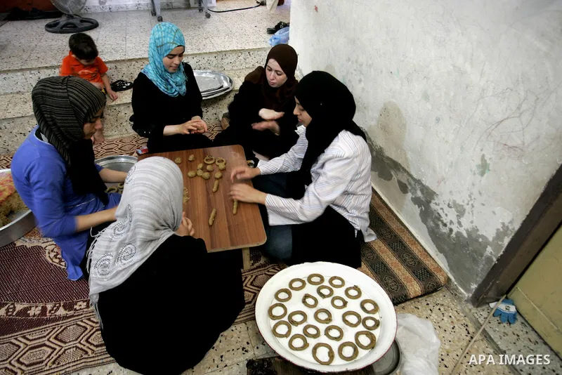 Palestinian women prepare date-filled mini cakes traditional for the Eid al-Fitr, a three-day holiday that marks the end of the fasting month of Ramadan,In their home in Rafah, southern Gaza Strip on Aug. 28, 2011. Photo...