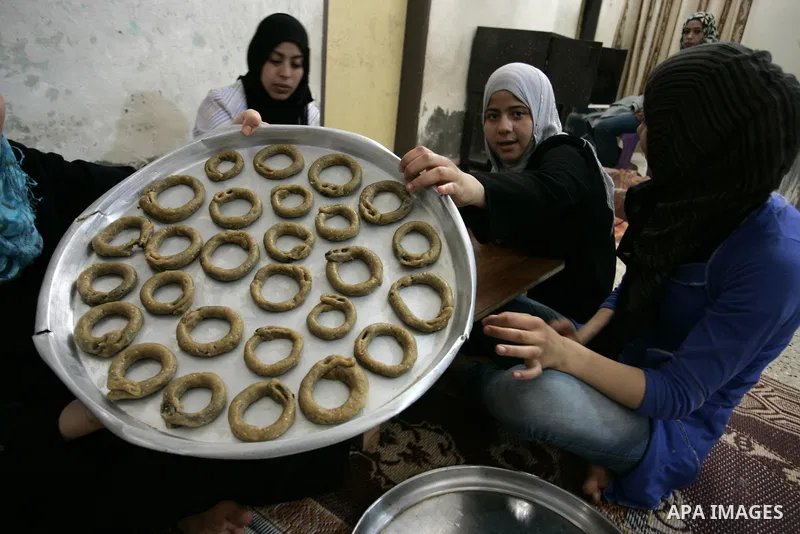 Palestinian women prepare date-filled mini cakes traditional for the Eid al-Fitr, a three-day holiday that marks the end of the fasting month of Ramadan,In their home in Rafah, southern Gaza Strip on Aug. 28, 2011. Photo...