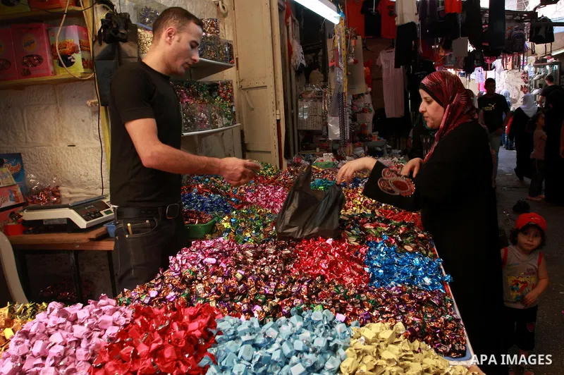A Palestinian vendor sells sweets at a market, as Muslims shop ahead of the Eid al-Fitr celebrations in the West Bank city of Nablus on Aug. 28, 2011. Muslims in the region will celebrate the Eid Al-Fitr with the sightin...