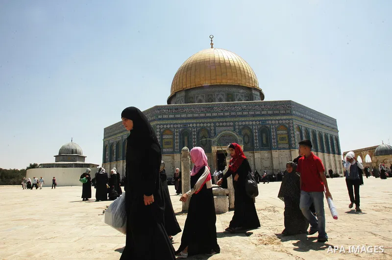 Palestinian Muslims walk past the Dome of the Rock in the al-Aqsa mosque compound in Jerusalem's old city 28 August 2011. Muslims throughout the world buy clothes and other popular items to prepare for The Eid aL-Fitr ,t...