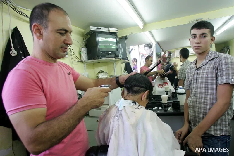 A Palestinian barber shaves for his customers ahead of Eid al-Fitr in Jerusalem's old city August 29, 2011. Eid al-Fitr marks the end of the Muslim holy month of Ramadan. Photo by Mahfouz Abu Turk