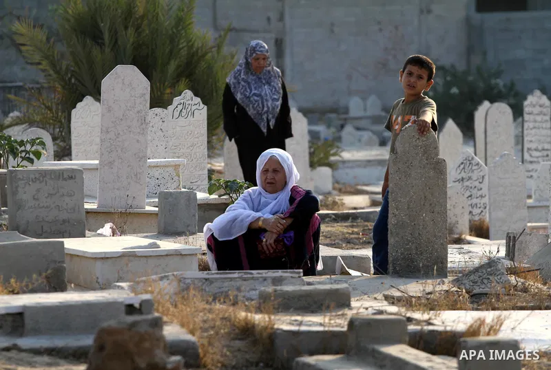 Palestinians visit their relatives' graves in a cemetery during the first day of Eid al-Fitr in Gaza city on August 30, 2011. Eid al-Fitr marks the end of the Muslim holy month of Ramadan. Photo by Mohammed Asad