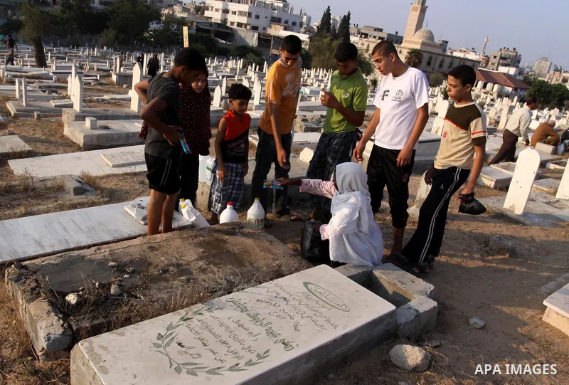 Palestinians visit their relatives' graves in a cemetery during the first day of Eid al-Fitr in Gaza city on August 30, 2011. Eid al-Fitr marks the end of the Muslim holy month of Ramadan. Photo by Mohammed Asad