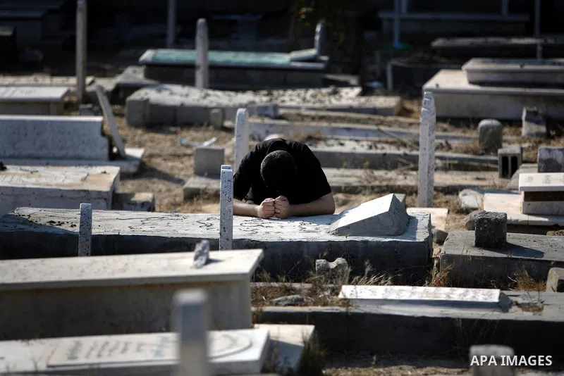 Palestinians visit their relatives' graves in a cemetery during the first day of Eid al-Fitr in the southern Gaza Strip on August 30, 2011. Eid al-Fitr marks the end of the Muslim holy month of Ramadan. Photo by Ali Jada...