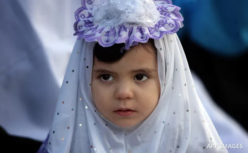 A Palestinian girl attends an open air morning prayer to celebrate Eid al-Fitr in Khan Yunis town the southern Gaza Strip on August 30, 2011. The Palestinian Territories, along with other neighboring and Gulf states, ann...