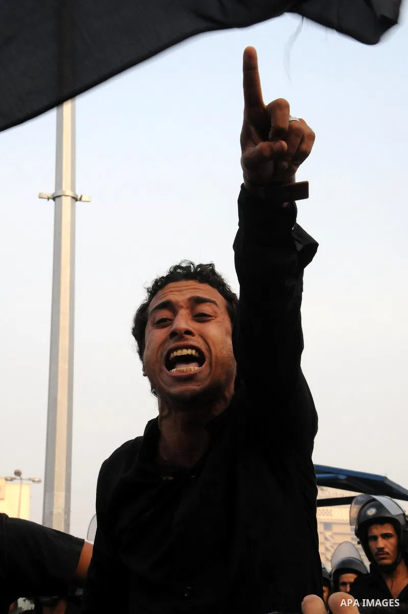 A man shouts slogans as Egyptian Muslims gather to pray, celebrating the start of the three-day feast known in Arabic Eid al-Fitr, which marks the end of the holy fasting month of Ramadan, in Tahrir Square, the scene of...