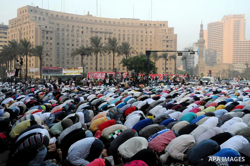 Police and military stand guard as Egyptian Muslims gather to pray, celebrating the start of the three-day feast known in Arabic Eid al-Fitr, which marks the end of the holy fasting month of Ramadan, in Tahrir Square, th...