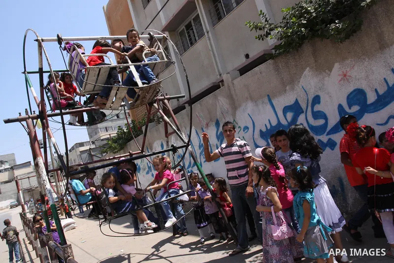 Palestinian children enjoy a ride at an amusement park on the second day of the Eid al-Fitr holiday, which marks the end of the holy fasting month of Ramadan in Gaza City, on August 31 2011. Photo by Mohammed Asad