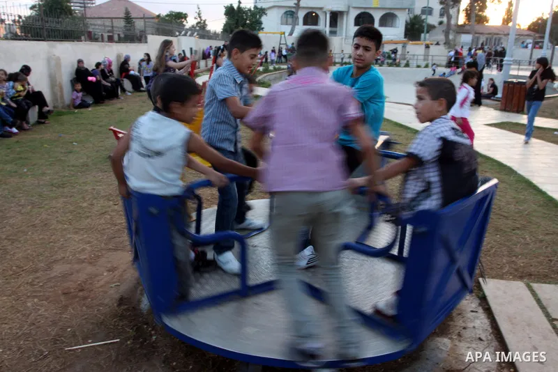 Palestinian children enjoy a ride at an amusement park on the second day of the Eid al-Fitr holiday, which marks the end of the holy fasting month of Ramadan, in the West Bank city of Ramallah, 31 August 2011. Photo by I...