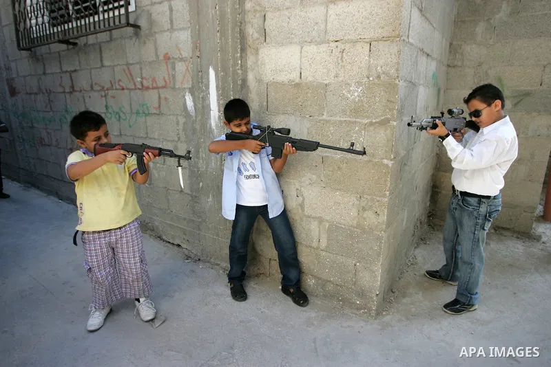 Palestinian boys play with toy guns on the third day of the Eid al-Fitr holiday in Rafah Refugee Camp in the southern Gaza Strip on 01 September 2011. Eid marks the end of the holy month of Ramadan. Photo by Abed Rahim K...
