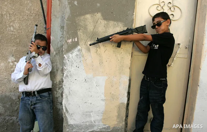 Palestinian boys play with toy guns on the third day of the Eid al-Fitr holiday in Rafah Refugee Camp in the southern Gaza Strip on 01 September 2011. Eid marks the end of the holy month of Ramadan. Photo by Abed Rahim K...