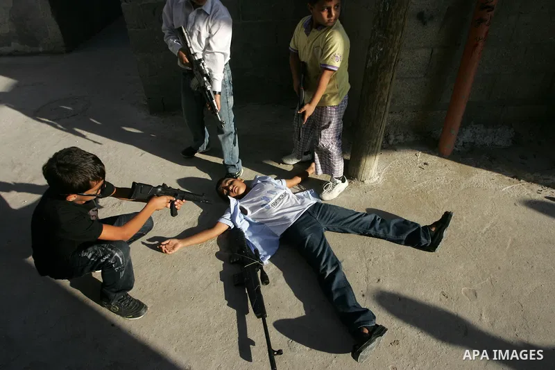 Palestinian boys play with toy guns on the third day of the Eid al-Fitr holiday in Rafah Refugee Camp in the southern Gaza Strip on 01 September 2011. Eid marks the end of the holy month of Ramadan. Photo by Abed Rahim K...