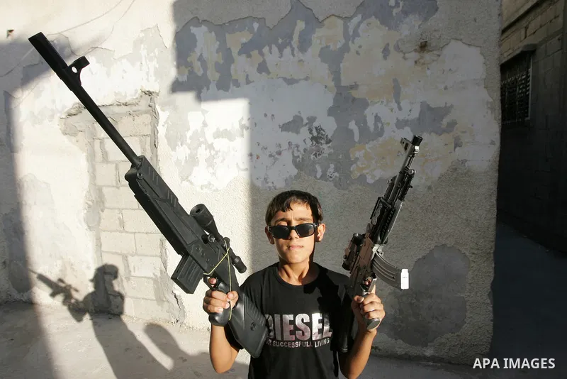 Palestinian boys play with toy guns on the third day of the Eid al-Fitr holiday in Rafah Refugee Camp in the southern Gaza Strip on 01 September 2011. Eid marks the end of the holy month of Ramadan. Photo by Abed Rahim K...