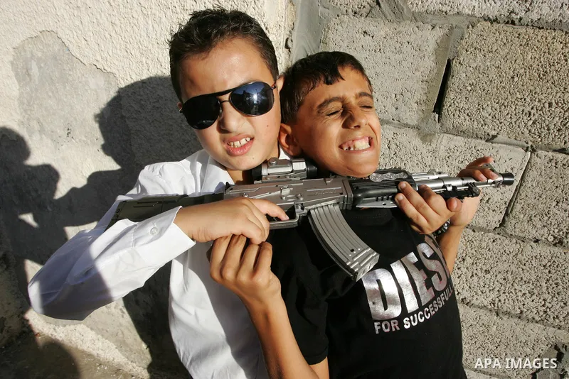 Palestinian boys play with toy guns on the third day of the Eid al-Fitr holiday in Rafah Refugee Camp in the southern Gaza Strip on 01 September 2011. Eid marks the end of the holy month of Ramadan. Photo by Abed Rahim K...