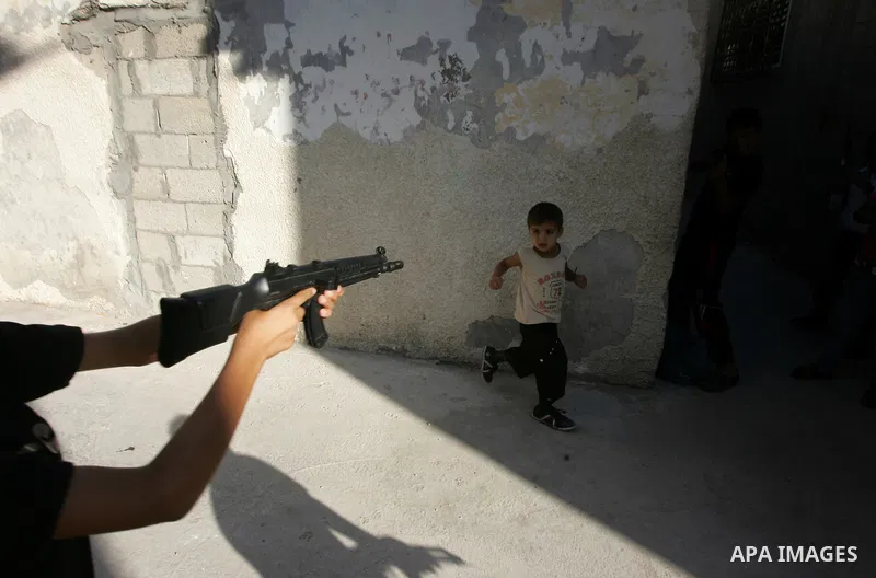 Palestinian boys play with toy guns on the third day of the Eid al-Fitr holiday in Rafah Refugee Camp in the southern Gaza Strip on 01 September 2011. Eid marks the end of the holy month of Ramadan. Photo by Abed Rahim K...