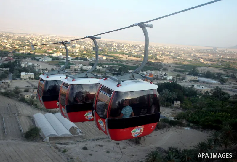 Tourists tour the historic sites of Jericho in cable cars during celebrations on the third day of the Eid al-Fitr holiday, which marks the end of the holy fasting month of Ramadan in the West Bank city of Jericho on Sept...